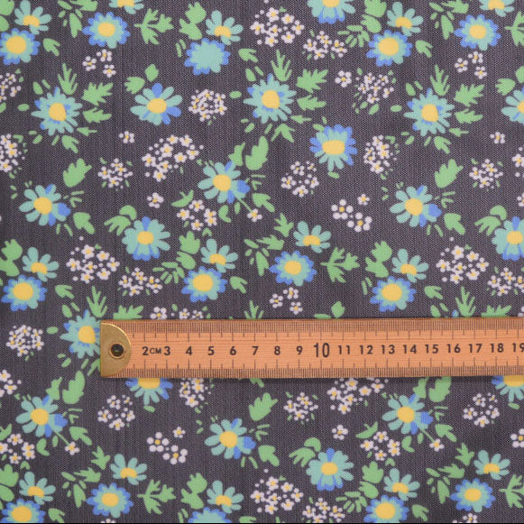 Floral patterned fabric with a ruler for scale on a dark background